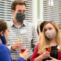 Group of people chatting while holding drinks